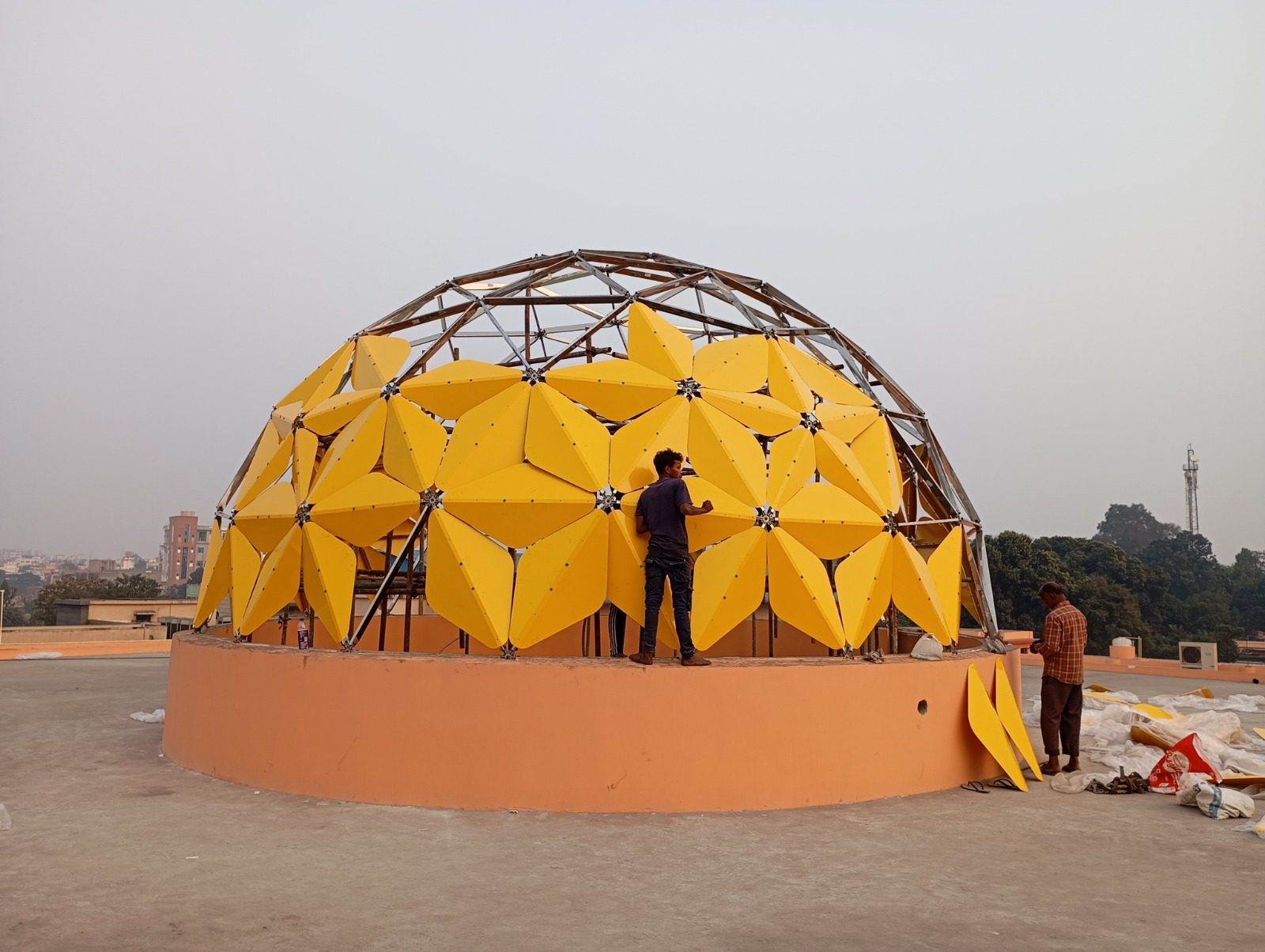 Yellow cladding panels being installed across the dome