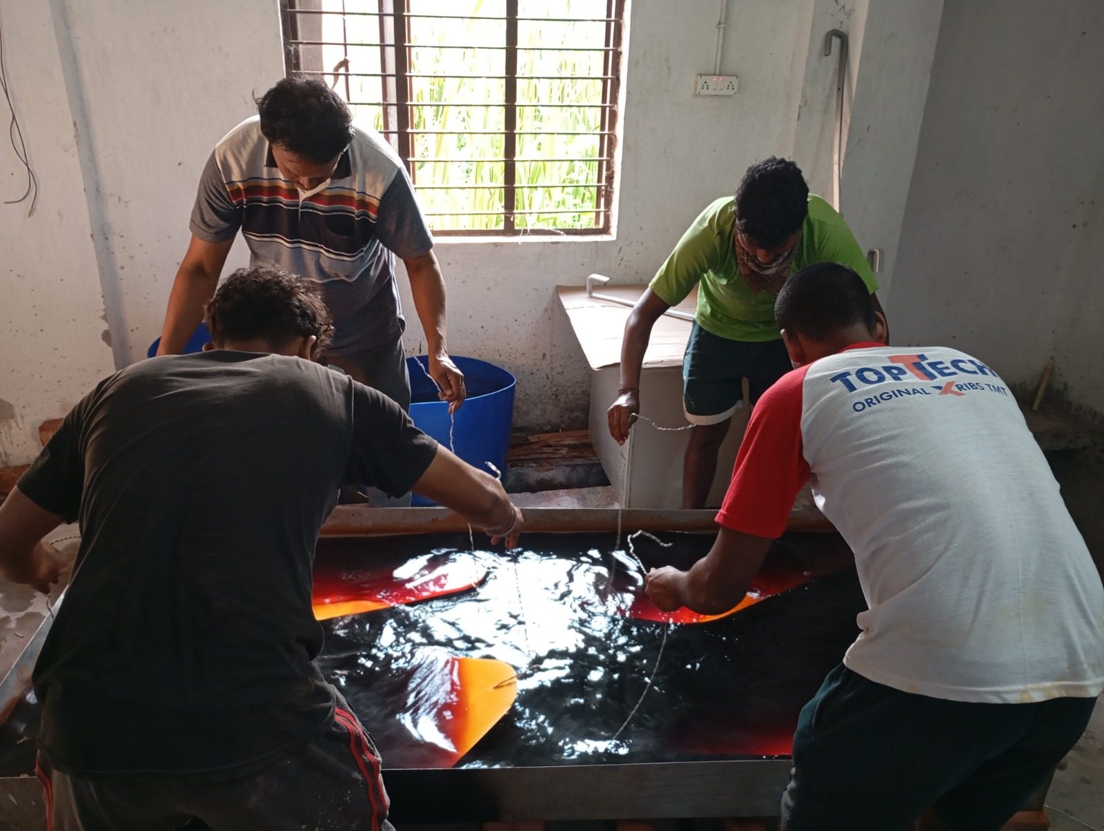 Workshop team treating cladding panels by hand